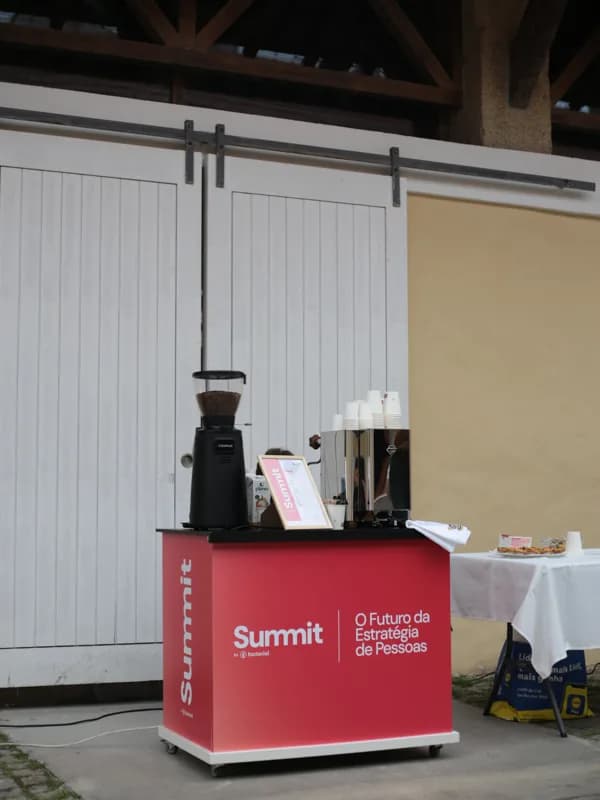 Vista geral da barra montada, com máquina espresso, moinho e placa do menu, sem pessoas em plano.